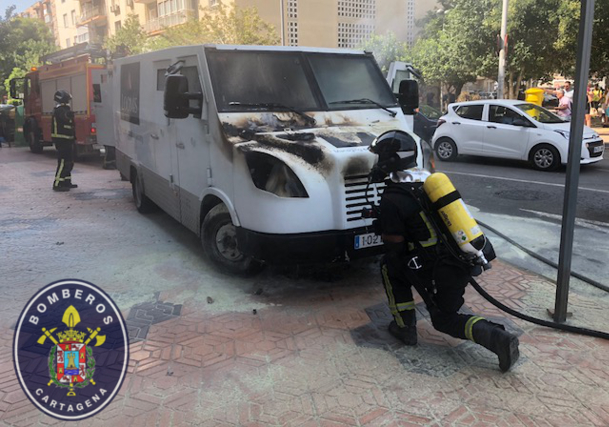 Bomberos sofocando el incendio de un furgn de seguridad