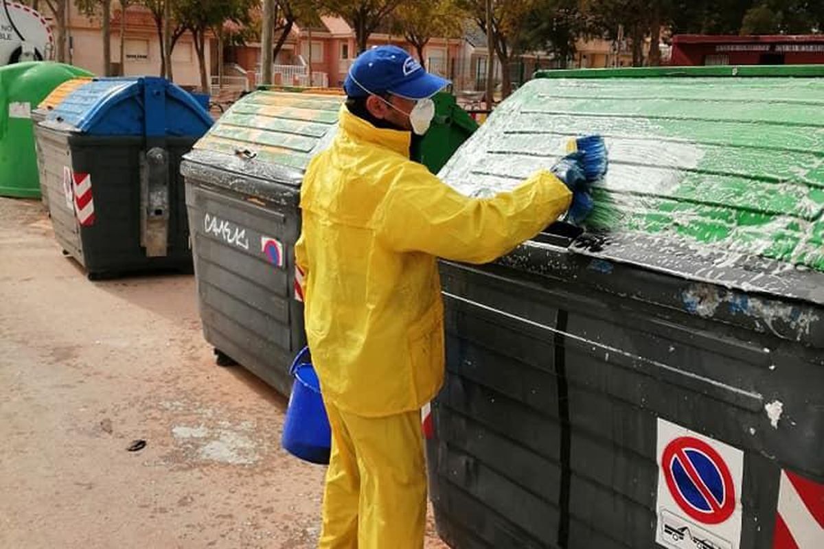 Trabajador de la empresa concesionaria desinfecta un contenedor de basuras