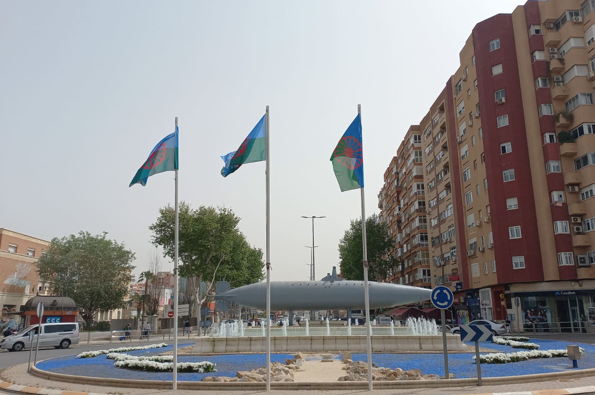 Banderas del pueblo gitano en los mstiles de la fuente del submarino