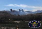 Bomberos sofocando un incendio de matorral en la zona de Los Mateos