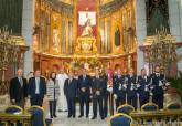 La Polica Local entrega un bandern a la Caridad.