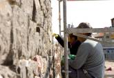 Restauradores trabajando en el muro de andesita