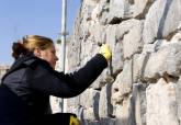 Restauradores trabajando en el muro de andesita