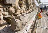 Restauradores trabajando en el muro de andesita